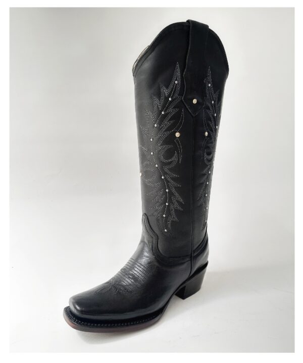Bota vaquera para dama en piel de res color negro, con diseño de tubo alto, bordado detallado y aplicaciones brillantes. Horma rodeo para mayor comodidad y suela de cuero para resistencia y agarre óptimos.