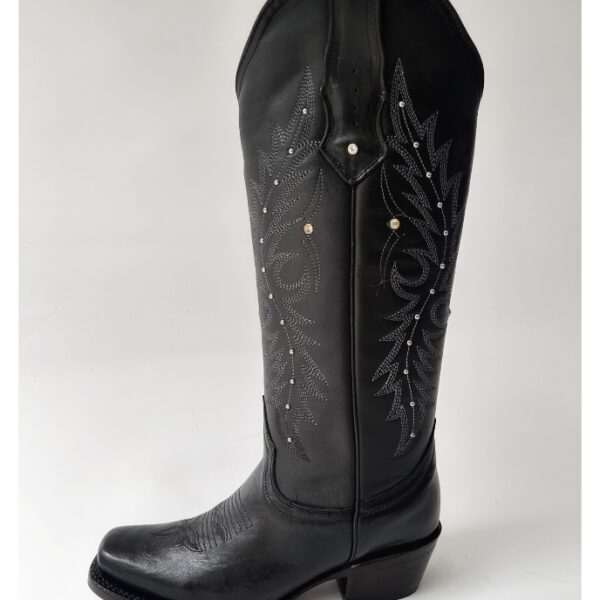 Bota vaquera para dama en piel de res color negro, con diseño de tubo alto, bordado detallado y aplicaciones brillantes. Horma rodeo para mayor comodidad y suela de cuero para resistencia y agarre óptimos.