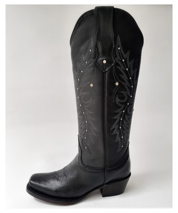 Bota vaquera para dama en piel de res color negro, con diseño de tubo alto, bordado detallado y aplicaciones brillantes. Horma rodeo para mayor comodidad y suela de cuero para resistencia y agarre óptimos.
