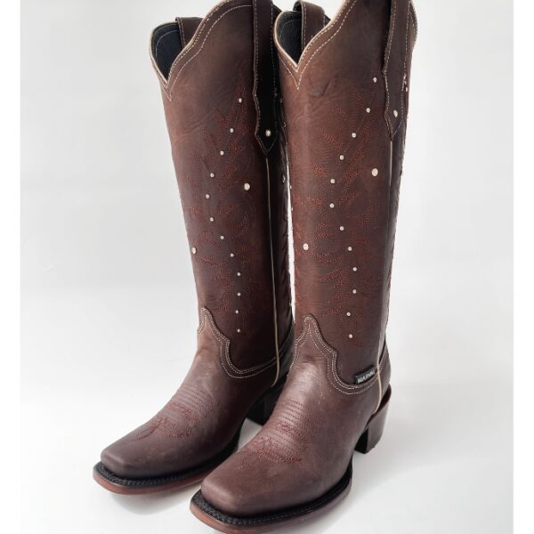Bota vaquera para dama en piel de res color CAFÉ, con diseño de tubo alto, bordado detallado y aplicaciones brillantes. Horma rodeo para mayor comodidad y suela de cuero para resistencia y agarre óptimos.