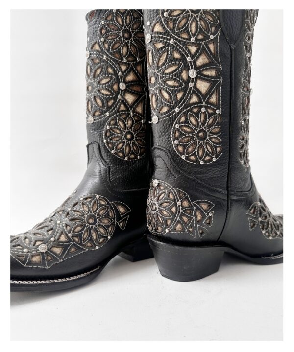 Bota vaquera de dama en piel de res color negra, con un diseño de bordado láser estilo atrapasueños en el tubo y la parte inferior.
