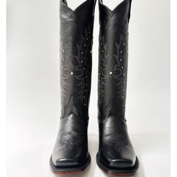 Bota vaquera para dama en piel de res color negro, con diseño de tubo alto, bordado detallado y aplicaciones brillantes. Horma rodeo para mayor comodidad y suela de cuero para resistencia y agarre óptimos.