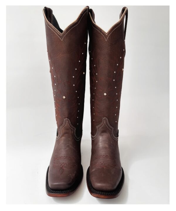 Bota vaquera para dama en piel de res color CAFÉ, con diseño de tubo alto, bordado detallado y aplicaciones brillantes. Horma rodeo para mayor comodidad y suela de cuero para resistencia y agarre óptimos.
